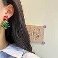 Close-up of handmade beaded Christmas tree earrings with red bow on female model - Christmas Tree Bow-Silver Pin / Stud Earrings