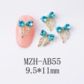 Détail du bijou d'ongle nœud doré 9,5x11mm avec strass cœur bleu clair et rubans - Nœud Bleu Lac (AB55)