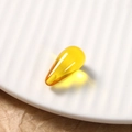 Macro shot of a yellow translucent teardrop resin bead with visible internal particles - 1 Piece / Transparent Yellow