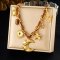 Gold stainless steel necklace with celestial charms and moon pearl on beige jewelry box - Gold & Brown Leather Braided Multi-Pendant Style (N3844)