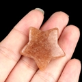 Star-shaped natural sunstone crystal gemstone held in hand for size reference - Strawberry Quartz