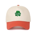 Detailed close-up of lucky clover embroidery on a two-tone color block trucker cap - Adjustable / Off-White & Orange-Red