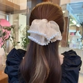 Elegante scrunchie in organza beige con perle su capelli castani in un ambiente naturale - Champagne Oversize Perla