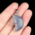 Hand holding a labradorite moon face pendant with grey and blue natural textures - Blue Aventurine