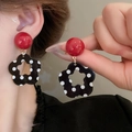 Close-up of earrings featuring red beads and black floral pendants with white polka dots - 22# Earring Clip-Red-Black (Red & Black Polka Dot Flower)