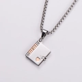 Close-up of a silver book-shaped pendant with rose gold spine and heart cutout details - Rose Gold