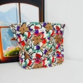 Macro detail of floral canvas tote bag featuring beige fabric with colorful flower patterns - Colorful Cartoon Flowers