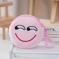 Close-up of pink plush coin purse with embroidered smiley face on mini wooden chair - Light Pink
