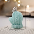 Light blue knitted glove shaped scented candle on a book with festive bokeh lights - Blue Gloves - Rosemary Mint