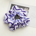Dettaglio del motivo ondulato blu e viola su un elastico per capelli in morbido tessuto - Motivo a onde viola
