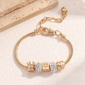 Bracelet à breloques doré avec pendentifs couronne et cœur sur pierre texturée - Bracelet Perlé Or (4077)
