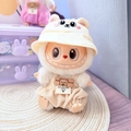 Labubu doll in beige waffle overalls and bear hat sitting with bear gloves label - White Bunny Hat + Apricot Checkered Overalls / First And Second Generation Keychains Are Compatible With La Cloth Dolls. Dolls Not Included.