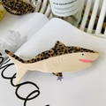 Details der Haarklammer mit Leopardenmuster auf einem Magazin mit glänzender Textur - Dunkler Schildpatt Hai