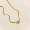 Vista dettagliata dall'alto di una collana dorata minimalista con zircone tondo singolo - Catena a O Dorata