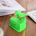 Dispenser stuzzicadenti a uccellino verde con meccanismo a pressione su tavolo legno - Uccello Verde Base Verde