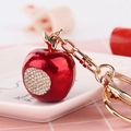 Sparkling red apple keychain with rhinestones and gold hardware on a white ceramic tray - Red Enamel Small Apple