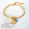 Vergulde roestvrijstalen schakelarmband met letter M en blauwe edelsteen hanger. - M / Staalkleur