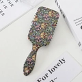 Vista cenital de un cepillo de pelo vintage con calaveras sobre un fondo de libros - Múltiples Calaveras