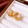 Detail of vintage square gold earrings with clear cubic zirconia in a wooden jewelry box - Gold Hoop Earrings