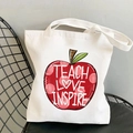 White canvas tote bag with red heart apple design and Teach Love Inspire text print - Red Apple Text
