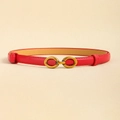 Detail view of red slim leather belt with a golden horsebit buckle on beige surface - Red