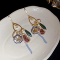 Close-up of vintage drop earrings with sparkling crystals and long chain tassels - Gold