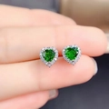 Green heart-shaped moissanite stud earrings in S925 silver held on a fingertip - Green Diamond Heart-shaped Earrings Led-78