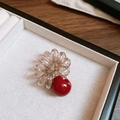 Dettaglio di un elastico a spirale marrone con pendente a ciliegia rossa in una scatola - Elastico per capelli a spirale cavo telefonico con sfera in acrilico / Rosso