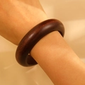 Close-up of a polished dark brown sandalwood bracelet showing natural wood grain on a wrist - 2.2cm Slim Style (02 Brown 2176) / Brown