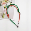 Detail of green and orange leather strap with decorative knot and silver buckle - Brown + Green