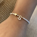Beaded crystal bracelet featuring a white shell letter S charm and gold heart bead - Letter S