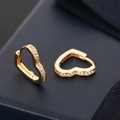 Macro shot of gold heart hoop earrings with white zircon pavé and snap closure - Heart Shape / Gold
