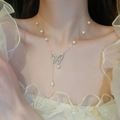 Detail of gold plated butterfly pendant necklace with freshwater pearl and zircon on model - Gold Plated Freshwater Pearl Butterfly Necklace