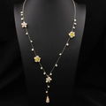 Collier élégant en fleurs de perles dorées avec gouttes blanches sur un buste noir chic - Chaîne de Pull Ornée de Fleurs