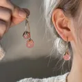 Detail of pink beaded cherry earrings with metal leaf design worn on model - 2# Silver Needle - Pink Berry Dangle