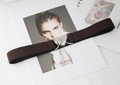 Détail d'une ceinture élastique marron avec boucle coeur argentée sur un magazine - Café
