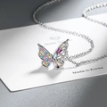 Dettaglio macro del ciondolo a farfalla in argento con zirconi colorati su catena fine - Rame / Oro Bianco