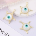 Close-up of golden starfish evil eye pendants on a purple surface with pearl accents - Starfish Eye