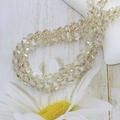 Macro shot of faceted champagne crystal glass beads with white daisy on wood - 6mm (approx. 100pcs) / Silver Champagne