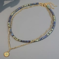 Double-layer bohemian turquoise beaded necklace with golden sun pendant on gray surface - Double Layer Sun Pendant
