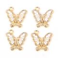 Dettaglio di quattro ciondoli a farfalla dorati con smalto bianco e strass scintillanti - KC Oro-Bianco