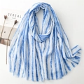 Detailed macro view of blue and white striped cotton-linen scarf with golden glitter and fringe - Blue