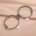 Magnetische Herz-Armbänder aus graublauem Webkordel für Paare auf Seidenhintergrund - Blaugrau