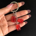 Dettaglio di ciondoli a forma di orsetto rosso su un portachiavi in metallo argento puro - Rosso