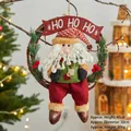 Christmas wreath with Santa doll, rattan ring, and HO HO HO banner for holiday door decor - Sitting Santa Style