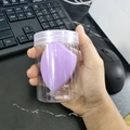 Purple teardrop-shaped makeup sponge in a transparent jar with a white lid - Cylindrical Box / Light Purple