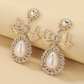 Dettaglio macro degli orecchini a fiocco con perle a goccia e pavé di cristallo - Pendaglio a Goccia con Perla e Fiocco Dorato (HE6245) / Oro