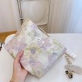 Vue détaillée du tissu jacquard floral et de l'étiquette tissée sur la pochette - Fleur d'Or Feuille Rose