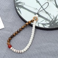 Dettaglio del cinturino per cellulare con radice di Bodhi, occhio di tigre e agata rossa su ventaglio - Pietra Naturale Occhio di Tigre + Perle di Bodhi (K3444)