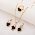 Detail view of gold jewelry set featuring black heart stones and micro-inlaid diamonds - Three-Piece Set / Heart - Black